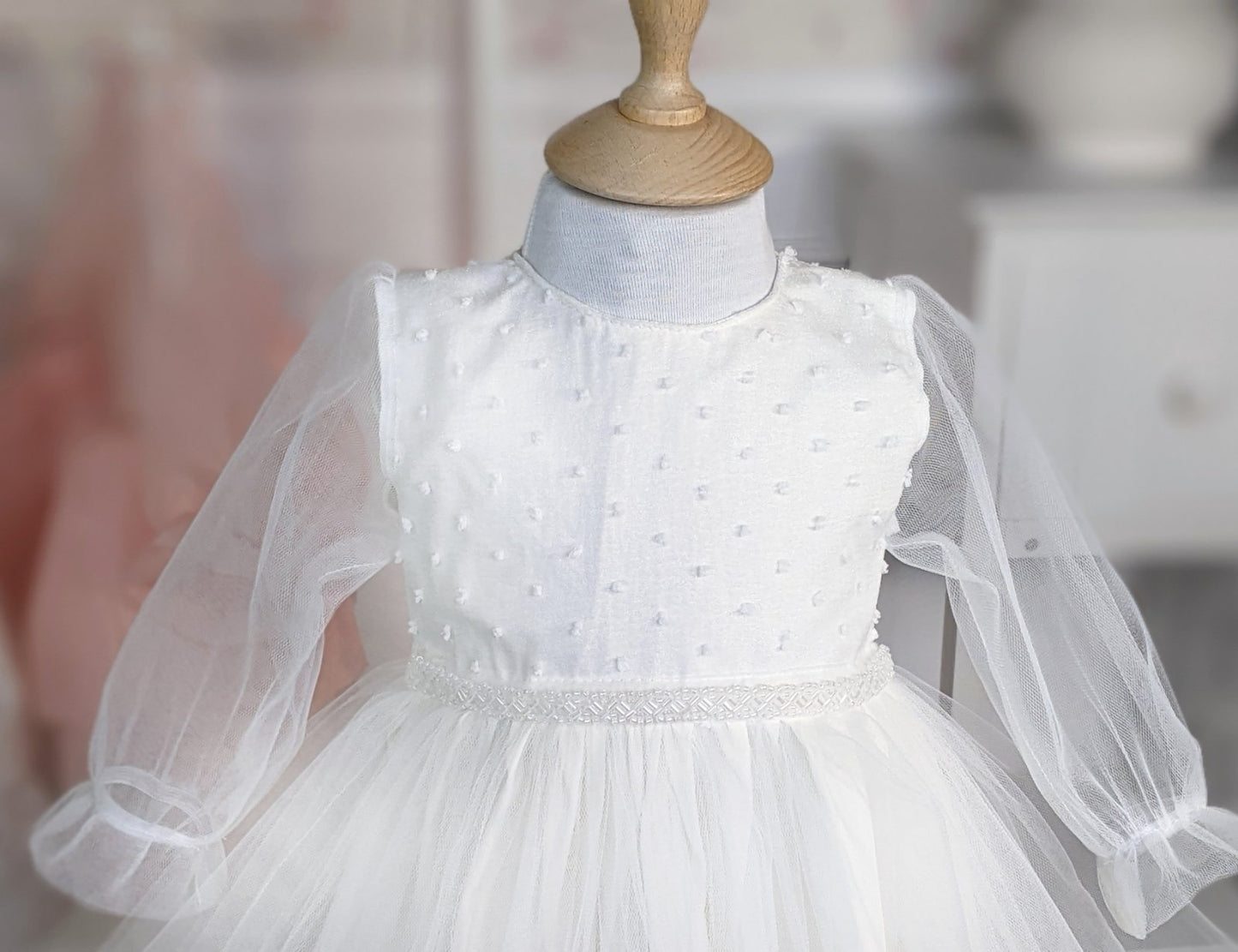 Bela haljina sa tufnama u gornjem delu i biserima na struku