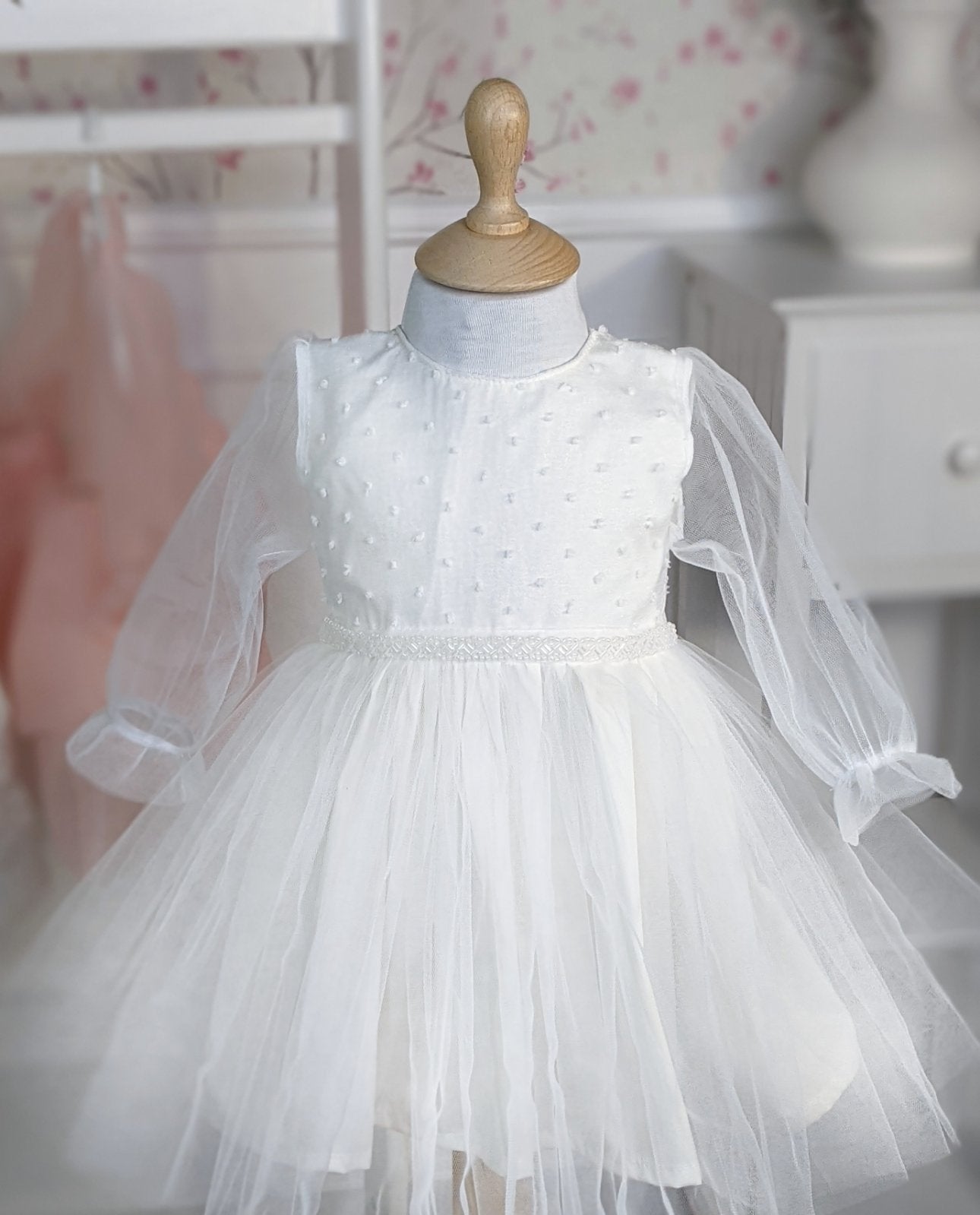 Bela haljina sa tufnama u gornjem delu i biserima na struku