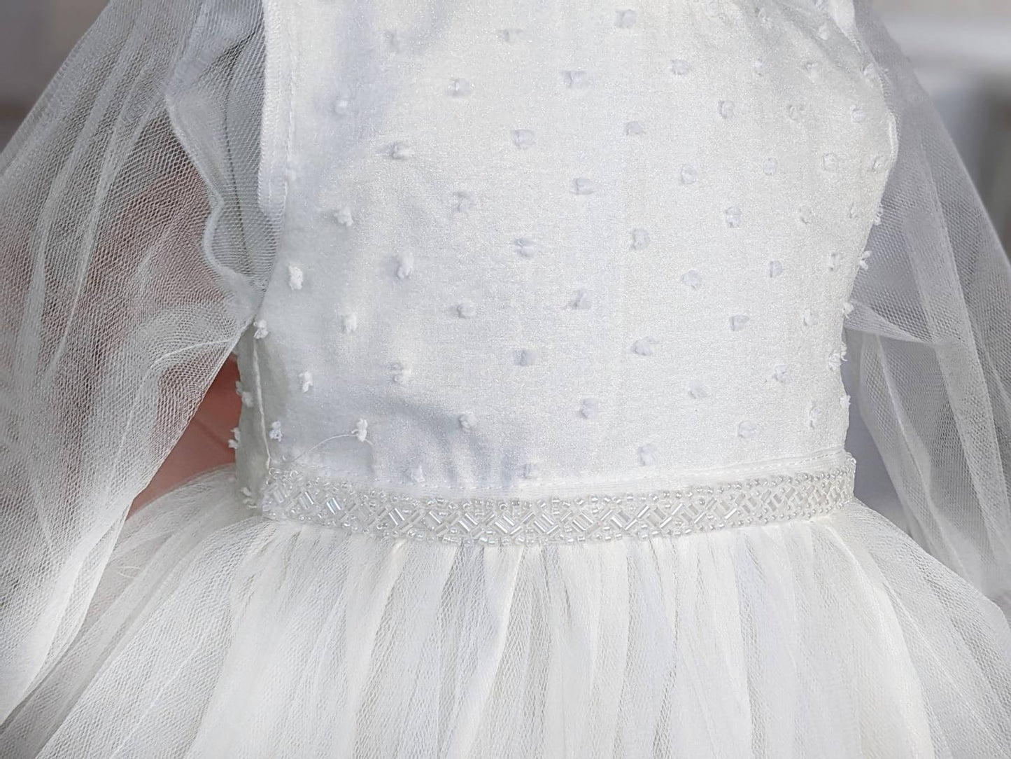 Bela haljina sa tufnama u gornjem delu i biserima na struku